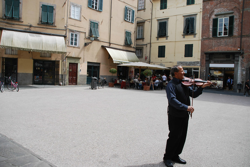 Op een plein in Lucca kan je zomaar verrast worden door een mooi vioolspel!